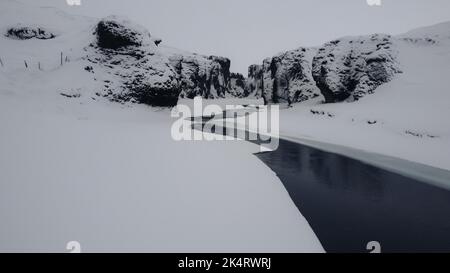 Verschneiter Fluss in island, einem gefrorenen Canyon aus Stein, verloren. Stockfoto