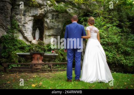 Brautpaar. Braut und Bräutigam stehen draußen vor dem Altar und beten zusammen. Stockfoto