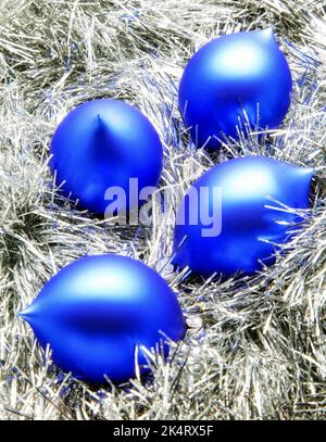 Blaue weihnachtskugeln auf silberner Dekoration. Stockfoto