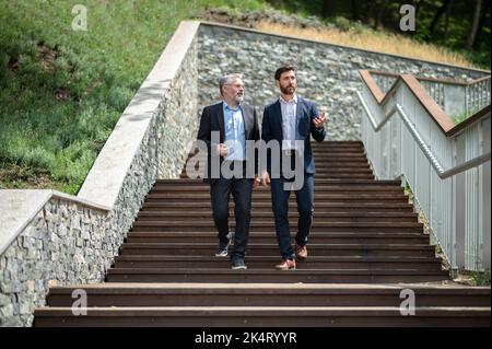 Zwei Geschäftsleute, die die Treppe hinunter gingen und sich unterhielten Stockfoto