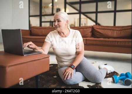 Konzentrierte zufrieden fit Frau, die sich auf das Heimtraining Stockfoto