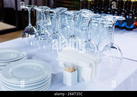 Set mit sauberem Geschirr und Gläsern auf dem Tisch vor weißem Hintergrund Stockfoto