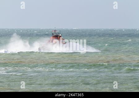 Newhaven Rettungsboot orange und blau auf See mit starken Winden und Meeresspray rund um das Schiff starke Wellen auch Schaukeln das Boot Stockfoto