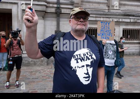 ANMERKUNG DER REDAKTION: Das Bild enthält einen Obszönitäten-Protestler in einem T-Shirt, der Bye bye twat über eine Illustration des aktuellen und scheidenden Premierministers Boris Johnson in Westminster liest, als der Gewinner des Führungsrennens der Konservativen Partei am 5.. September 2022 in London, Großbritannien, bekannt gegeben wird. Liz Truss MP gewann den Wettbewerb und wird die neue Tory-Partei-Führerin und kommende Premierministerin. Stockfoto
