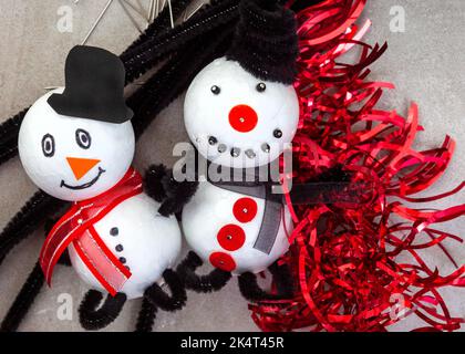 Kinder Weihnachtsbasteln von Schneemann und Kranz Ornamente mit Polystyrol, Schnur, Pfeifenreiniger und mehr. Stockfoto