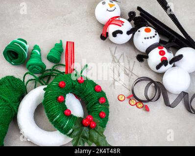 Kinder Weihnachtsbasteln von Schneemann und Kranz Ornamente mit Polystyrol, Schnur, Pfeifenreiniger und mehr. Stockfoto