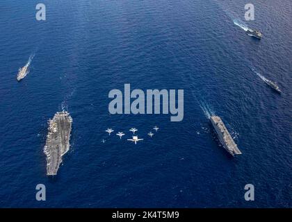 Ionisches Meer. 27. September 2022. Der Flugzeugträger USS George H.W. der Nimitz-Klasse Bush (CVN 77) und der Arleigh Burke-Klasse-Lenkflugkörper-Zerstörer USS Truxtun (DDG 103) segeln in Formation neben den spanischen Marine-Schiffen ESPS Juan Carlos I (LHD 61), ESPS Navarra (F 85), Und ESP Castilla (L 52) als Carrier Air Wing (CVW) 7 und spanische Vorboten führen einen Überflug während kombinierter Operationen im Ionischen Meer durch, am 27. September 2022. Carrier Air Wing (CVW) 7 ist die offensive Luft- und Schlagkomponente von CSG-10 und GHWBCSG. Die Staffeln von CVW-7 sind: Strike Fighter Squadron (VFA) 143, VFA-103, VFO-86, Stockfoto