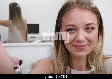 Junge erstaunliche glücklich hübsche Dame. Frau Bloggerin zeigt, wie man Make-up und verwenden Kosmetik. Vor der Kamera zur Live-Aufzeichnung von Vlog-Videos Stockfoto