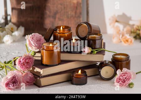 Ein Set verschiedener Duftkerzen in braunen Glasgefäßen. Handgemachte Duftkerze. Sojalkerzen brennen in einem Glas. Aromatherapie und entspannen Sie sich im Spa und zu Hause. Feuer in braunem Glas. Stockfoto