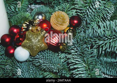 Künstliche Tannenzweige mit Christbaumspielzeug Stockfoto