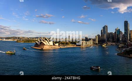 Das Sydney Opera House am Bennelong Point mit den Wolkenkratzern am Circular Quay an einem sonnigen Nachmittag Stockfoto