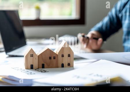 Mann Agent Berechnung Darlehen der Finanzierung und Investitionen für Immobilien, Geschäftsmann und investieren in Immobilien über Haus, Bau oder Hypothek von zu Hause. Stockfoto