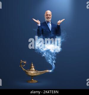 Der Geschäftsmann Genie, der aus einer magischen Lampe kommt, lächelt und schaut in die Kamera Stockfoto