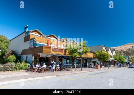 Eine Reihe kleiner Geschäfte, Bistros und Restaurants an der Ardmore Street in Wanaka, einem kleinen Sommer-/Winterskiort in der Region Otago von South Island in Stockfoto