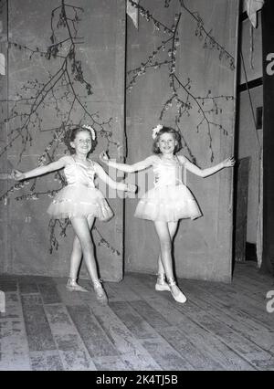 1961, historisch, zwei junge Mädchen in ihren Ballettkostümen auf einer Holzbühne beim MaiDay Carnival in Leeds, England, Großbritannien Stockfoto