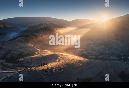 Luftaufnahme von Bergen und Hügeln in niedrigen Wolken bei Sonnenaufgang Stockfoto