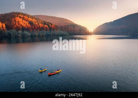 Luftaufnahme von Menschen auf Booten auf blauem See in Bergen Stockfoto