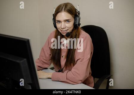 Ein zufriedener Call Center-Agent, der an einer Support-Hotline im Büro arbeitet. Der Call Center-Operator spricht mit dem Kunden. Nahaufnahme. Ein Telemarketer, ein Stockfoto