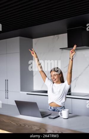 Aufgeregte Freiberuflerin Heben Sie die Hände hoch Schrei horay in Freude feiern Abschluss der Arbeit an schwierigen Projekt. Stockfoto