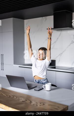 Aufgeregte Freiberuflerin Heben Sie die Hände hoch Schrei horay in Freude feiern Abschluss der Arbeit an schwierigen Projekt. Stockfoto