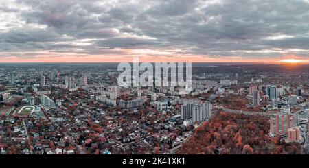 Luftaufnahme lebhaft rot Herbst Stadtpark Sonnenuntergang Panoramablick mit epischen Wolkenlandschaft. Wohnquartiergebäude im Abendlicht. Charkiw, Ukraine Stockfoto