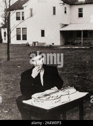 Elvis Presley c 1956, Essen aus einem gitarrenförmigen Kuchen. „Willkommen zu Hause Elvis“. Graceland. Stockfoto