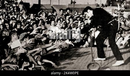 Foto aus TV Radio Mirror, März 1957 - Elvis tritt live auf dem Mississippi-Alabama Fairgrounds in Tupelo, Mississippi, auf. Stockfoto