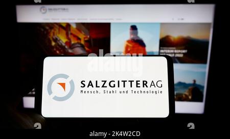 Person, die Smartphone mit Logo des deutschen Stahlunternehmens Salzgitter AG auf dem Bildschirm vor der Website hält. Konzentrieren Sie sich auf die Telefonanzeige. Stockfoto