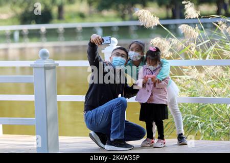 Shijiazhuang, Chinas Provinz Hebei. 4. Oktober 2022. Menschen nehmen Selfies im Donghuan Park in Shijiazhuang, der Hauptstadt der nordchinesischen Provinz Hebei, am 4. Oktober 2022. Quelle: Luo Xuefeng/Xinhua/Alamy Live News Stockfoto