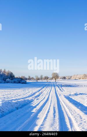 Autospuren im Schnee auf einer Winterstraße Stockfoto