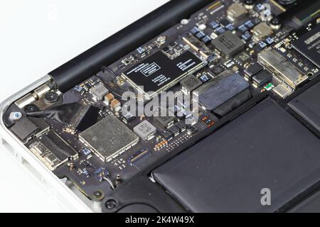 Laptop-Computer wird repariert, Mainboard, WLAN-Modul, Akku und SSD sichtbar. Stockfoto