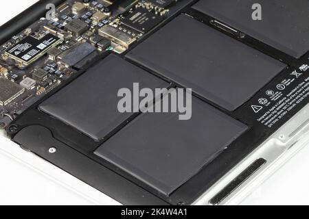 Laptop-Computer wird repariert, Mainboard, WLAN-Modul, Akku und SSD sichtbar. Stockfoto