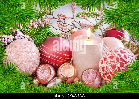 Weihnachtsdekoration mit Kerze, Tannenzweigen und Kugeln Stockfoto