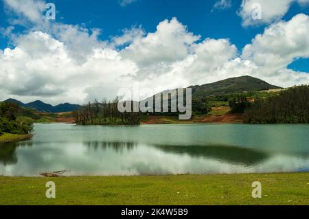 Hoch aufragende Berge, Fluss mit sichtbarer kleiner Insel, blauer und weißer Himmel, Spiegelung sichtbar im Wasser, das Geschenk der Natur von Grün überall ist der Weg Stockfoto