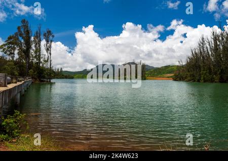 Hoch aufragende Berge, Fluss mit sichtbarer kleiner Insel, blauer und weißer Himmel, Spiegelung sichtbar im Wasser, das Geschenk der Natur von Grün überall ist der Weg Stockfoto