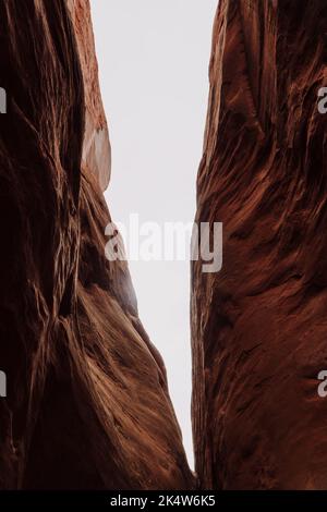 Der vertikale Tiefwinkel-Blick auf die Felsformationen und den hellen Himmel im Arches Nationalpark in Utah Stockfoto