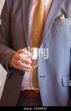 Mann in einem Anzug mit leerem Weinglas Stockfoto