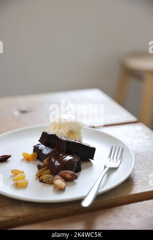 Brownies mit getrockneten Früchten und Eis auf Holzhintergrund Stockfoto