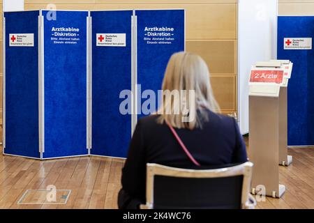 Kiel, Deutschland. 04. Oktober 2022. Eine Frau wartet vor einer Arztkabine. Am 4. Oktober 2022 veranstaltete der Blutspendedienst Nord-östlich des Deutschen Roten Kreuzes (DRK) im Kieler Landeshaus eine Blutspendekampagne. Zu diesem Zweck wurde der alte Plenarsaal in ein Blutspendezentrum umgewandelt. Blutspenden helfen, die medizinische Versorgung von Patienten zu sichern, die zum Beispiel im Zuge größerer Operationen oder zur begleitenden Chemotherapie nach Krebs dringend Präparate aus Spenderblut benötigen. Quelle: Frank Molter/dpa/Alamy Live News Stockfoto