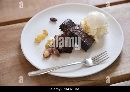 Brownies mit getrockneten Früchten und Eis auf Holzhintergrund Stockfoto