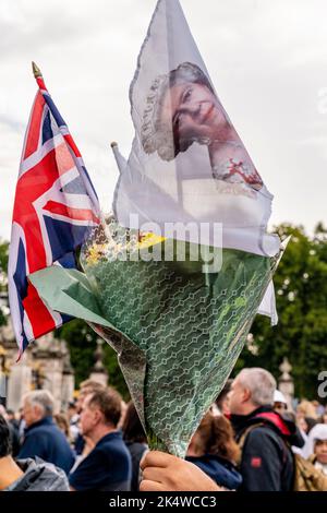 Der Tag nach dem Vergehen von Königin Elizabeth II. Kommt Ein Mann mit Einem Blumenschmuck vor dem Buckingham Palace in London an. Stockfoto