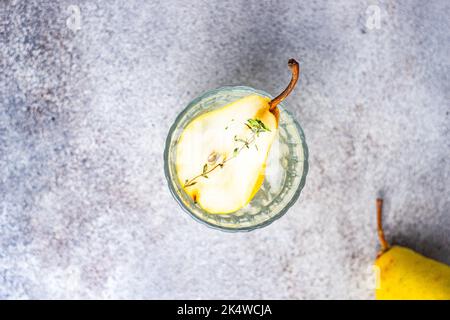 Blick von oben auf einen Birnen-Wodka und Tonic mit frischer Birne und Thymian Stockfoto