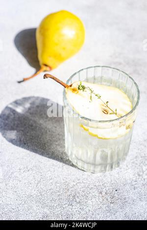 Nahaufnahme eines Birnen-Wodkas und Tonic mit frischer Birne und Thymian Stockfoto