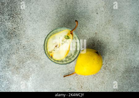 Blick von oben auf einen Birnen-Wodka und Tonic mit frischer Birne und Thymian Stockfoto