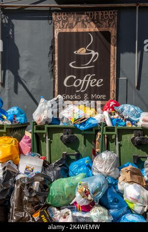 Müllsäcke, die sich vor einem Café in überfüllten Mülltonnen stapelten. Stockfoto