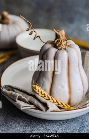 Nahaufnahme eines herbstlichen Ortes mit Ähren aus Weizen und einem dekorativen Keramikkürbis Stockfoto