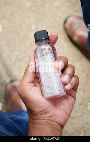 POV der Hand halten Sie einen Mundspülbehälter Stockfoto