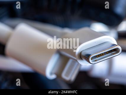 Schwerin, Deutschland. 04. Oktober 2022. Ein Ladekabel mit USB-C-Anschluss liegt neben einem Paket verschiedener Anschlusskabel. Ab 2024 soll es in der EU einheitliche Ladekabel geben. Das EU-Parlament hat dem einheitlichen USB-C-Ladestandard für Smartphones und viele andere Geräte seine endgültige Zustimmung erteilt. Quelle: Jens Büttner/dpa/Alamy Live News Stockfoto
