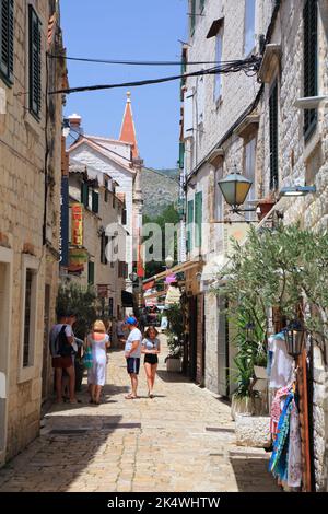 TROGIR, KROATIEN - 23. JUNI 2021: Touristen besuchen die Altstadt von Trogir, Kroatien. Trogir ist eine mittelalterliche Stadt in Dalmatien, die zum UNESCO-Weltkulturerbe zählt Stockfoto