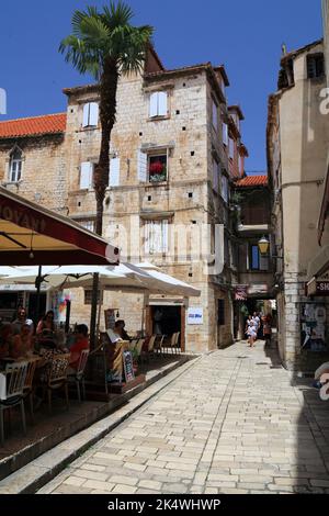 TROGIR, KROATIEN - 23. JUNI 2021: Touristen besuchen die Altstadt von Trogir, Kroatien. Trogir ist eine mittelalterliche Stadt in Dalmatien, die zum UNESCO-Weltkulturerbe zählt Stockfoto